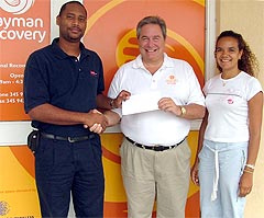 Chairman of Montessori's Parent's Guild, Mr. Phillip Ebanks and the school's administrator and part owner, Ms. Kourtni Jackson present a cheque to the National Recovery Fund's Executive Director, Dr. Mark Laskin.