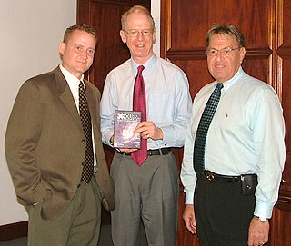 The 36-Hours DVD was presented to His Excellency The Governor Bruce Dinwiddy, CMG (centre) by documentary producers Ward Scott of GIS (left) and Rick Alpert of CITN (right)