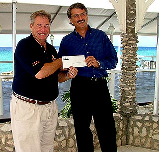 Dr. Mark Laskin, Executive Director of the National Recovery Fund receives a cheque from Grand Old House's Manager, Martin Richter, part proceeds from the recent rum festival.